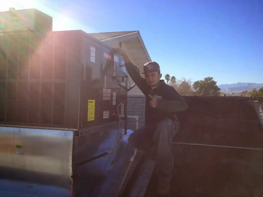 HVAC technician performing Air Duct Cleaning on a rooftop unit in Triangle